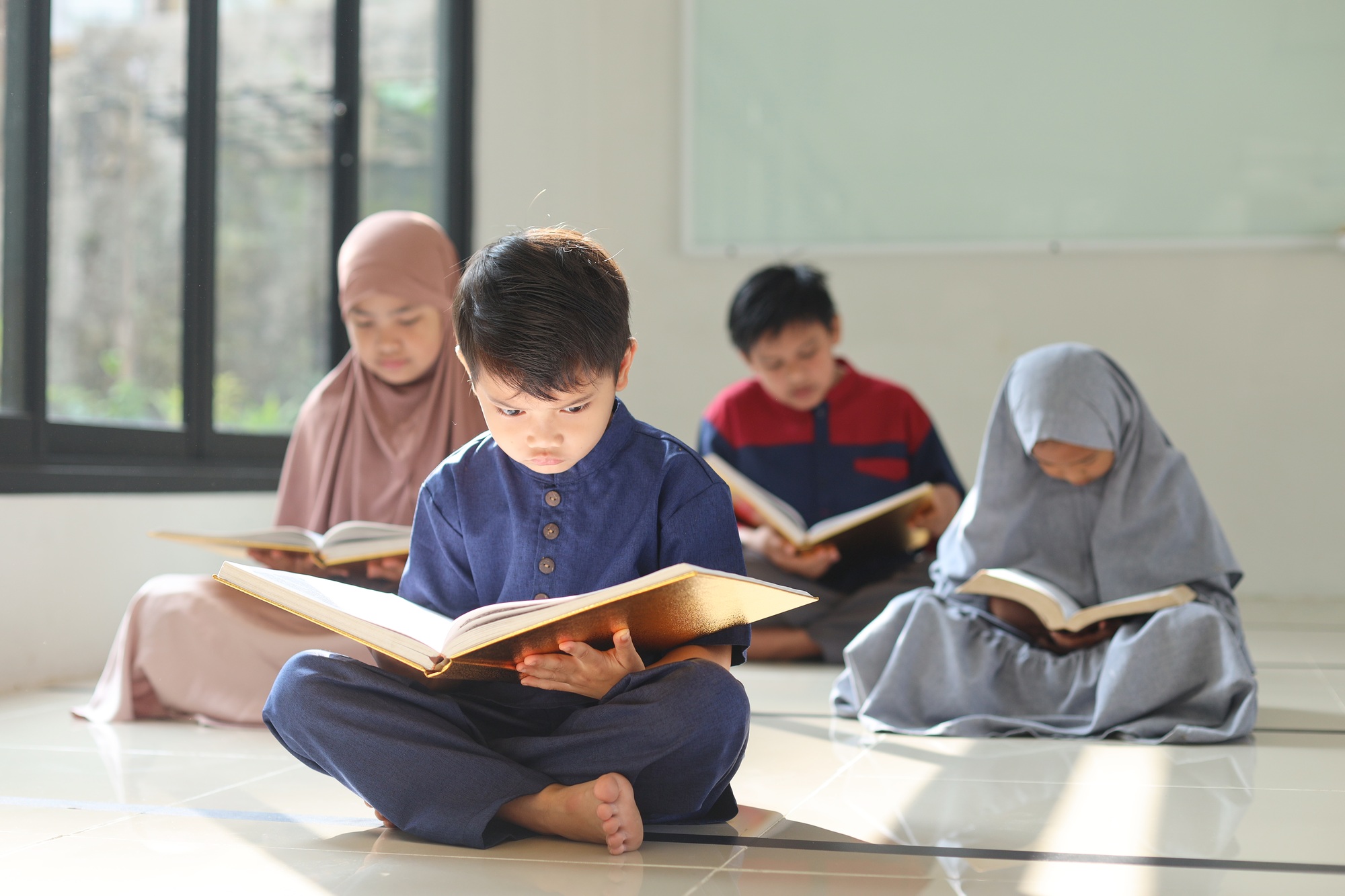 Little kid sitting in front and focus reading Kor